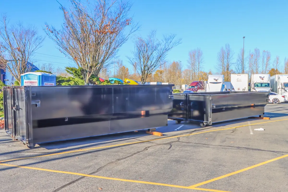 Professional dumpster rental service with roll-off container on residential driveway in East Bethel